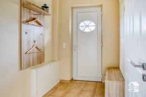 a hallway with a white door and a window at Appartement Sundevit in Börgerende-Rethwisch