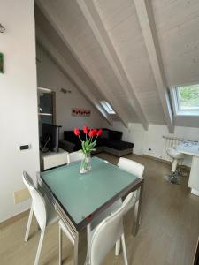 - un salon avec une table ornée de fleurs rouges dans l'établissement A casa di Laura Finale Ligure, à Finale Ligure