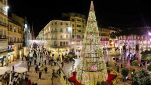 a large christmas tree in a city at night at Apartamento Piccadilly Suite in Torremolinos