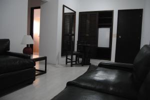 a living room with black leather furniture and a mirror at Hotel Iberia in Punta del Este