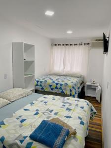 1 dormitorio con 2 camas y TV. en Pousada El Patron, en Penha