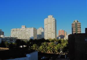 eine Skyline der Stadt mit hohen Gebäuden und Palmen in der Unterkunft Hotel Iberia in Punta del Este
