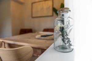 a glass bottle with flowers in it sitting on a table at Bed & Bos de 14 Sterren in Den Burg