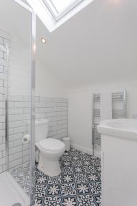 uma casa de banho com um WC, um chuveiro e um lavatório. em The Arches New Modern 2BR em Belfast