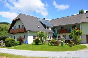 uma casa grande com um telhado de gambrel em Pension Holzmeister em Sankt Kathrein am Offenegg