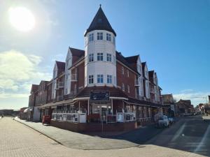 ein hohes Gebäude mit einem Uhrturm auf einer Straße in der Unterkunft Strandburg Juist Apartment 208 - Schwimmbad und Sauna kostenfrei in Juist