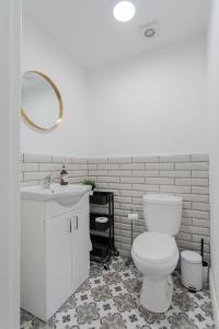 uma casa de banho com um WC branco e um lavatório. em The Arches New Modern 2BR em Belfast