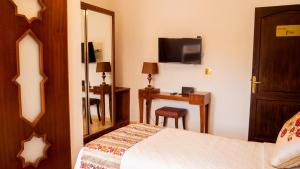 een slaapkamer met een bed, een spiegel en een bureau bij VILLA MATI Maison D'hôtes in Tetouan