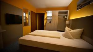 a bedroom with a large bed with white pillows at Hotel Windspiel in Grömitz