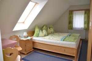 a small bedroom with a bed and a window at Pension Holzmeister in Sankt Kathrein am Offenegg