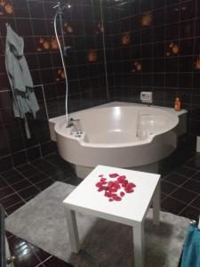 La salle de bains est pourvue d'une baignoire et d'une table fleurie. dans l'établissement Executive center rooms, à Bari