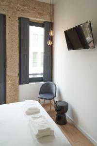 a bedroom with a bed and a chair and a tv at Brito Capelo 183 in Matosinhos