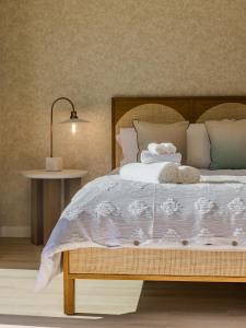 1 dormitorio con 1 cama grande con sábanas y almohadas blancas en @ Marbella Lane - Vibrant & Chic Designer Home, en Fullerton