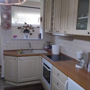 uma cozinha com armários brancos, um lavatório e um balcão em Ευρύχωρο διαμέρισμα σε ήσυχη γειτονιά em Kalamata