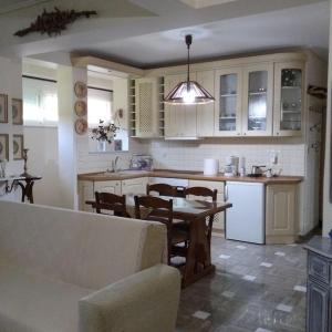 uma cozinha com mesa e cadeiras e uma cozinha com armários brancos em Ευρύχωρο διαμέρισμα σε ήσυχη γειτονιά em Kalamata