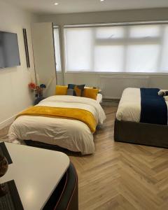 een slaapkamer met 2 bedden en een raam bij Luxury Studio- MK central- 5 MINS DRIVE TO TRAIN STATION-DIRECT TRAINS TO LONDON, BIRMINGHAM in Milton Keynes