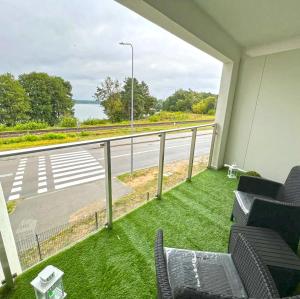 balcón con sillas y vistas a la carretera en Apartamenty nad jeziorem Białym KA-BOATS en Augustów