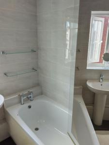 a white bathroom with a tub and a sink at Riverside in Liverpool