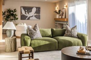 sala de estar con sofá verde y mesa en @ Marbella Lane - Vibrant & Chic Designer Home, en Fullerton