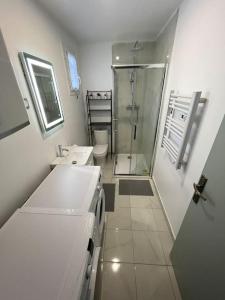 a bathroom with a shower and two sinks and a toilet at K2 - Maison 15 min PARIS PARC EXPOS - 3 chambres 6 lits in Bagneux