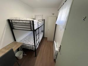 a small room with two bunk beds and a desk at K2 - Maison 15 min PARIS PARC EXPOS - 3 chambres 6 lits in Bagneux