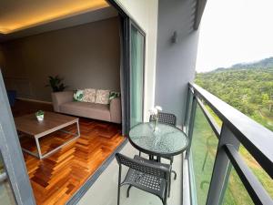 a balcony with a table and chairs and a couch at Cozy 2 Bedroom Suite Vista Genting FREE WIFI in Genting Highlands