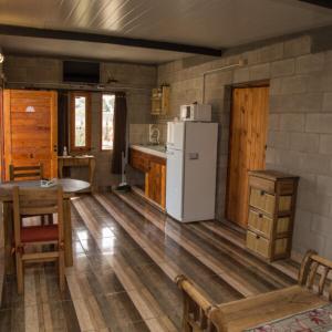 een keuken met een koelkast en een tafel en stoelen bij Nelumbo Petit Chalet in San Rafael +20 foto's