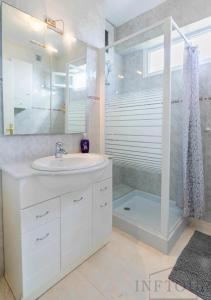 ein weißes Bad mit einem Waschbecken und einer Dusche in der Unterkunft Inftour Primavera Apartamento in Calpe
