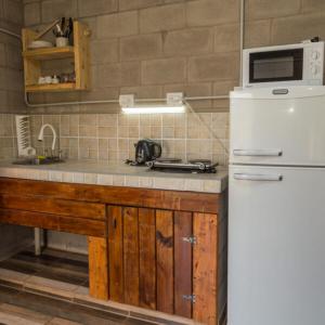 a kitchen with a sink and a white refrigerator at Nelumbo Petit Chalet in San Rafael