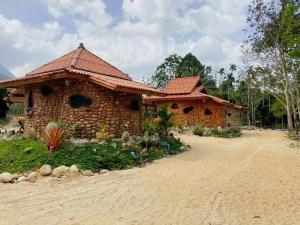 a brick building with a roof on a dirt road at ลีลา รีสอร์ท Leela Resort in Ban Tha Phae