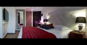 ミラノにあるカーサ カリカントゥスのベッドルーム1室(赤毛布付きの大型ベッド1台付)