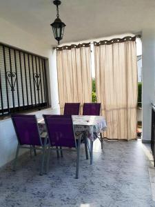 a dining room with a table and purple chairs at House near beach in Peñíscola for 4 in Peñíscola