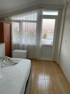 a bedroom with a bed and a large window at THE BEACH OTEL DİDİM in Didim