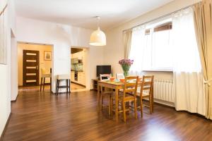 een eetkamer en een woonkamer met een tafel en stoelen bij Tyzenhauz Apartments Kazimierz in Krakau