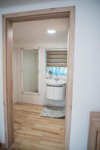 a bathroom with a tub and a sink and a mirror at Léleksimogató Vendégház in Kiskunhalas