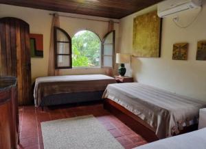 a bedroom with two beds and a window at Atelier Sylvio cavalheiro in Abraão
