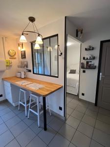 a kitchen with a wooden table in a room at L’Atelier de la dépendance in Lempdes sur Allagnon