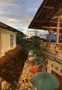 eine Terrasse mit Sonnenschirmen und Stühlen sowie ein Gebäude in der Unterkunft La Boheme Bajo in Labuan Bajo