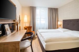 a hotel room with a bed and a desk at Hotel Flandrischer Hof in Cologne