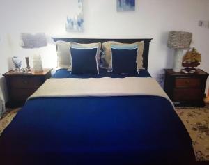 uma cama azul com almofadas azuis num quarto em Amazing Location! Walk to town, beach & dinner - PAYMENT REQUIRED TO RESERVE em Ocho Rios