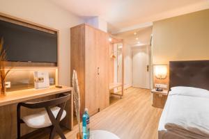 a hotel room with a bed and a desk with a computer at Hotel Flandrischer Hof in Cologne