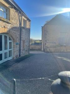 an empty street next to a brick building at Home Farm rooms in the grounds of Wentworth Castle in Barnsley