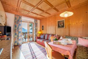 Adang Ferienwohnung Etschtal في تيرولو: غرفة معيشة مع أريكة وطاولة