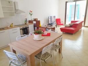 a kitchen and living room with a wooden table and chairs at CASA MARY in Menfi