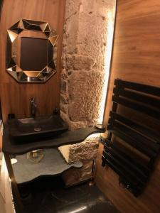 a bathroom with a sink and a tv on the wall at Le TULUM, T2, Hyper-centre, Place aux herbes in Mâcon