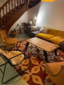ein Wohnzimmer mit einem Sofa und einem Couchtisch in der Unterkunft Maison charmante à 15mn à pied de la mer in Arradon