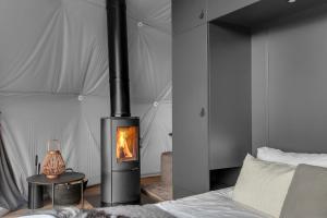 1 dormitorio con chimenea y 1 cama en Golden Circle Domes - Glamping Experience en Selfoss