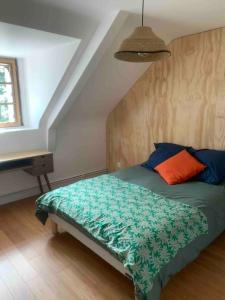 ein Schlafzimmer mit einem Bett mit einer grünen Bettdecke in der Unterkunft Maison charmante à 15mn à pied de la mer in Arradon