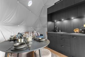 a kitchen with a table with plates and wine glasses at Golden Circle Domes - Glamping Experience in Selfoss