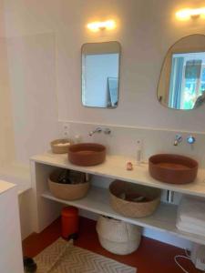 ein Badezimmer mit 2 Waschbecken und einem Spiegel in der Unterkunft Maison charmante à 15mn à pied de la mer in Arradon
